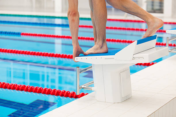 istock Young muscular swimmer in low position on starting block in 539647292