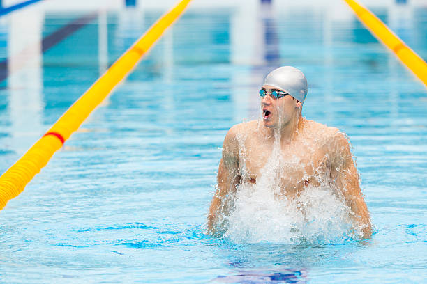 istock dynamic and fit swimmer in cap breathing performing jumping out 539647378