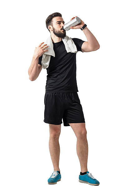 istock Young athlete drinking smoothie from bottle with towel around neck 539649666