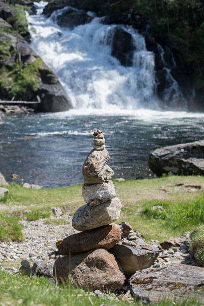 istock large natural waterfall with stones stacked into tower 539657258
