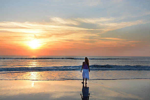 istock Woman  relaxing on the beach at sunrise. 539657312