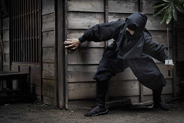 japanische ninja mit schwert verstecken hinter dem gebäude für ambush - liar dishonesty costume men stock-fotos und bilder