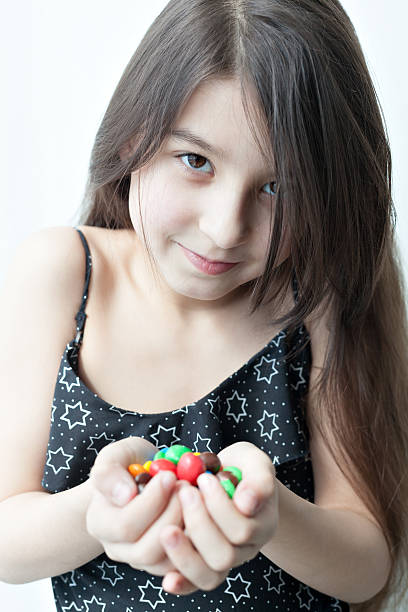 istock Little girl holding candy in the hands 539661486
