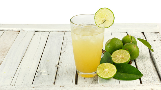 Cool drink - Glass of lime juice with ice on white wood  background