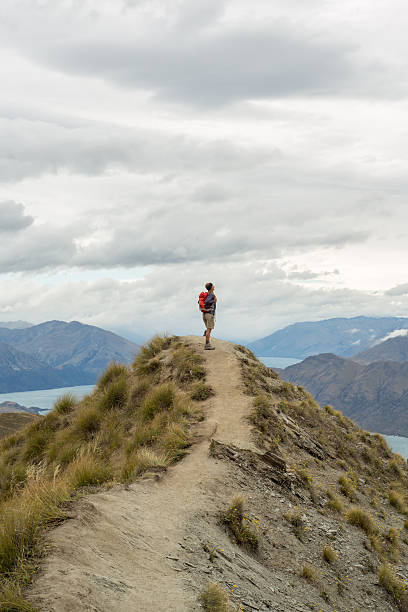 istock Hiker stands on mountain peak, looks at view 539668766