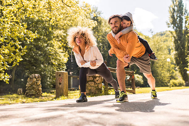 Young happy family doing stretching exercises in the park.