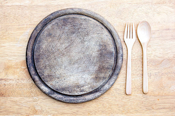 istock old round wooden cutting board with spoon and fork 539674080