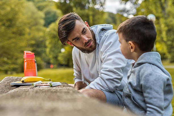 istock Young father talking to his small son in the park. 539674270