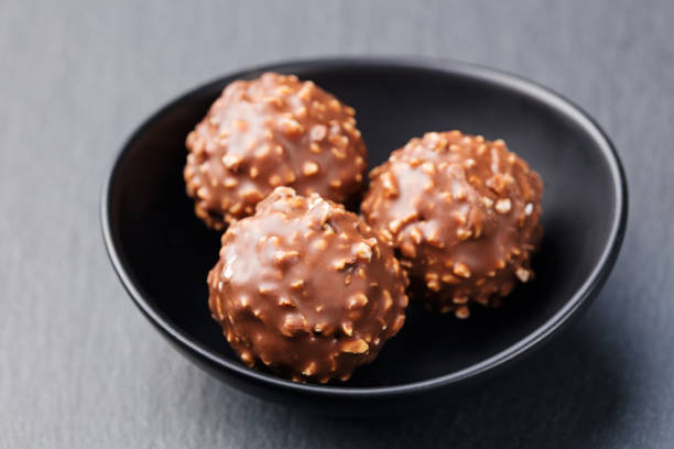 istock Chocolate candies, truffle in ceramic black bowl Grey slate background 539677824