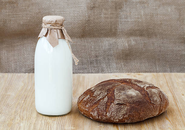 istock Rye bread with bottle of milk on wooden table 539681034