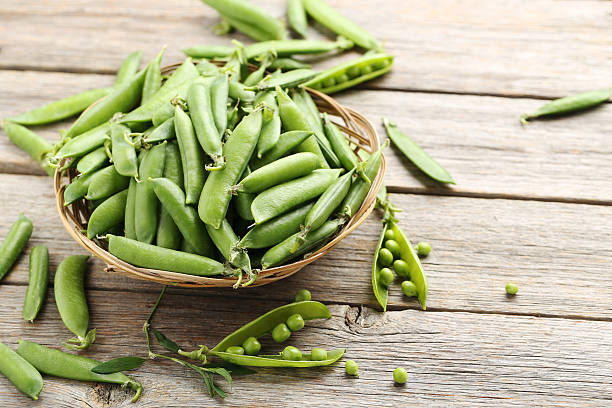 istock Green peas on a grey wooden table 539684302