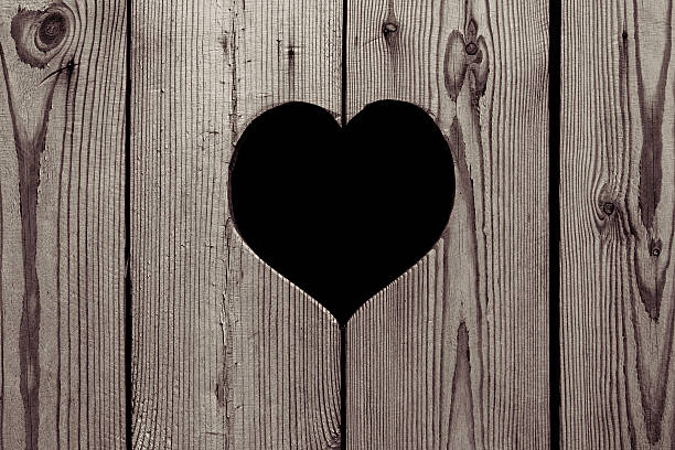 istock Light beige wooden background with a heart. 539686876