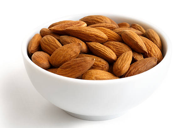 istock White bowl of whole almonds on white. 539687038