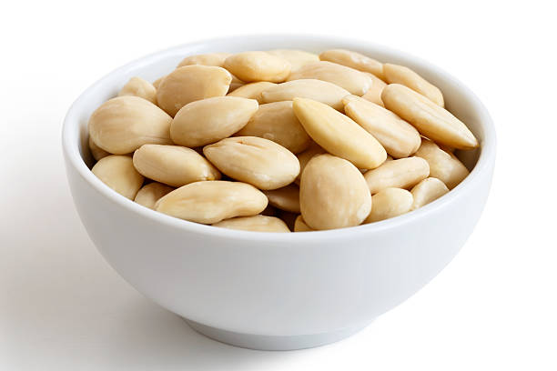 istock White bowl of peeled whole almonds isolated on white. 539687070