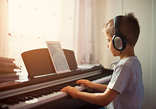 kleine junge üben moderne digitale klavier. - music learning child pianist stock-fotos und bilder