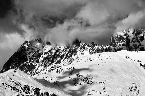 istock Black and white snowy rocks in haze at sunny day 539809732