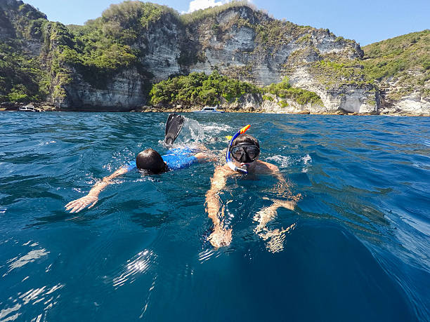 istock shoot of a young boy snorkeling with father 539810086