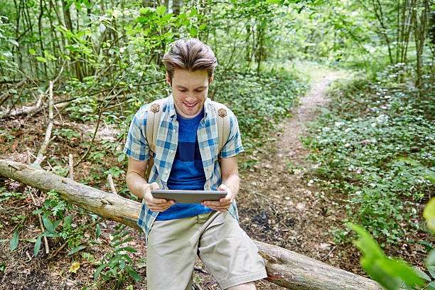 istock happy man with backpack and tablet pc in woods 539811276