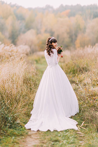 istock Young bride posing outdoors. Cute charming girl with forest hills 539814538