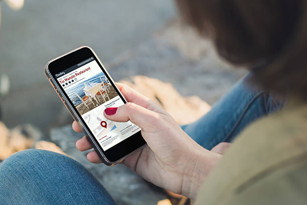 женщина и сенсорный экран ее смартфон с онлайн справочник - street directory стоковые фото и изображения