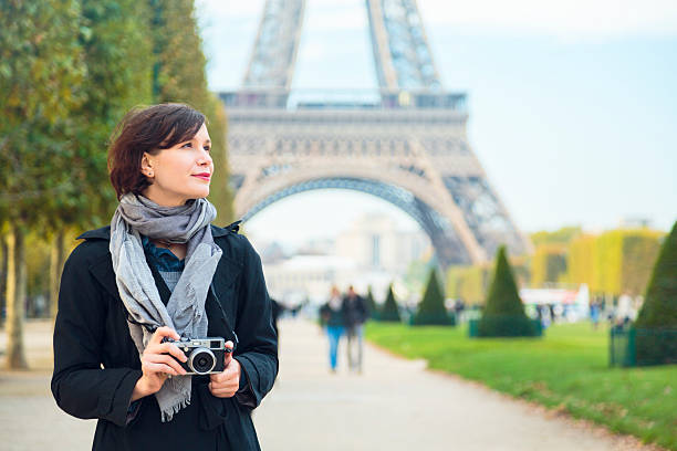 femme avec caméra sans miroir devant la tour eiffel, à paris - appareil photo compact photos et images de collection