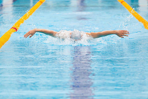 istock dynamic and fit swimmer in cap breathing performing the butterfly 539816628