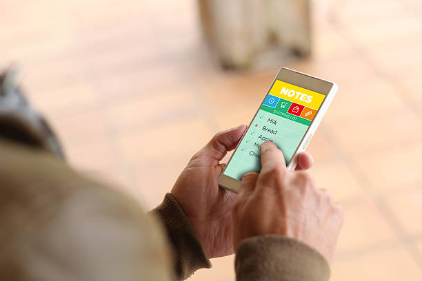 lifestyle concept: Hands male with smartphone app checking shopping list on the screen. All graphics on the screen are made up.