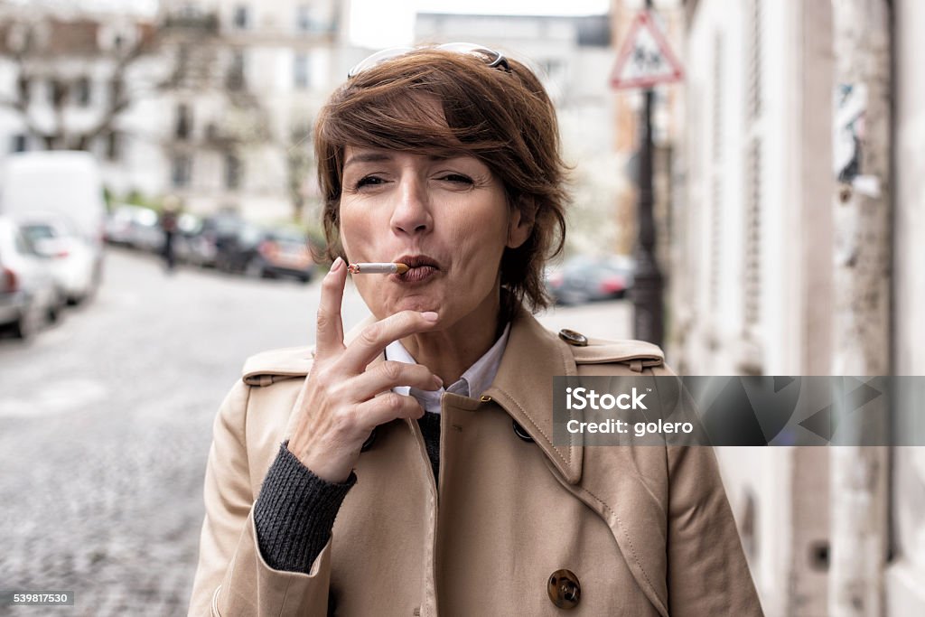 elegant parisian woman smoking at street Cigarette Stock Photo