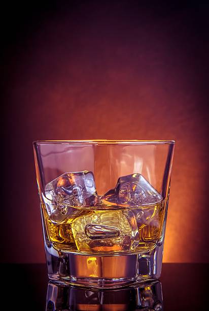 istock glass of whiskey on black table with reflection 539821792