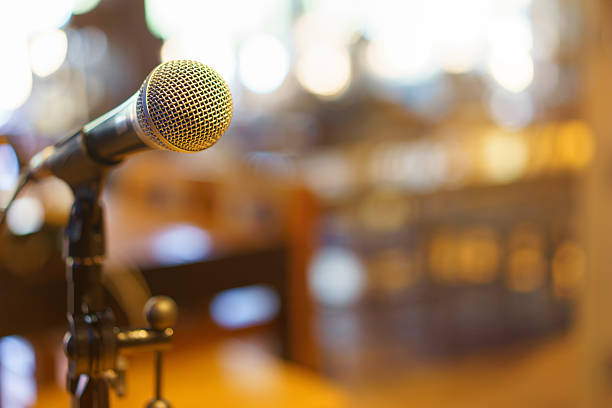 istock Microphone over the Abstract blurred photo of conference hall or 539825914