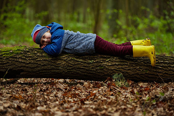 istock little funny boy on big log 539826520