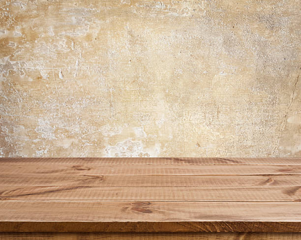 istock Wooden texture table surface over defocused ancient grunge wall background 539826532