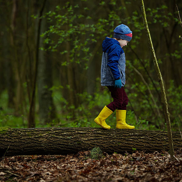 istock little funny boy on big log 539826738