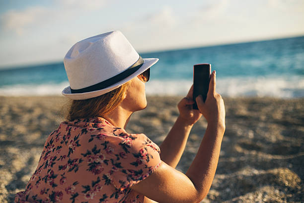 menina na praia enviar mensagens de texto em smartphone - women hawaii islands beach beauty in nature imagens e fotografias de stock