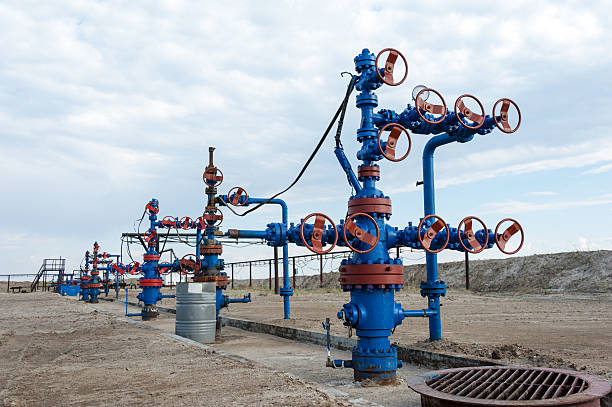 Oilfield. Concept oil and gas industry. Group production wellheads and conduit with valves. Oil and gas industry. oil wellhead stock pictures, royalty-free photos & images