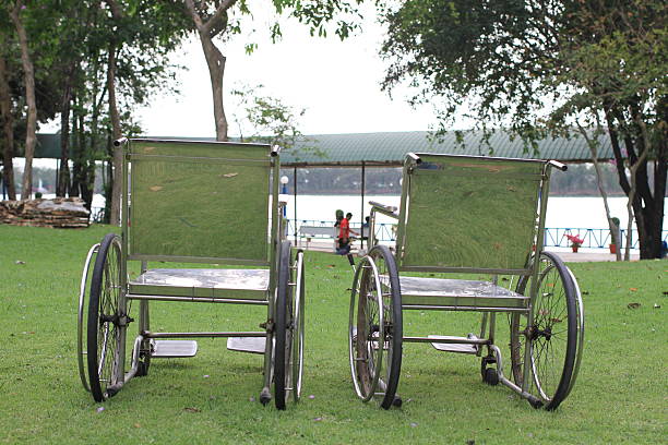 istock two wheelchairs  in the park against the river background 539829852