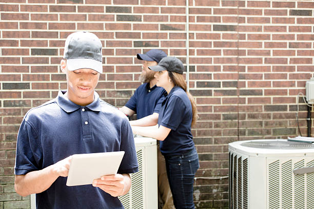 istock Air conditioner repairmen work on home unit. Blue collar workers. 539833578