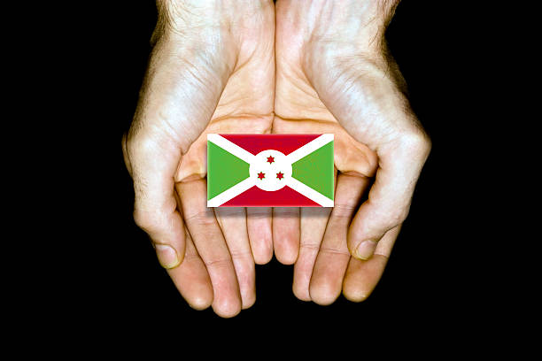 Flag of Burundi in hands isolated on black background.