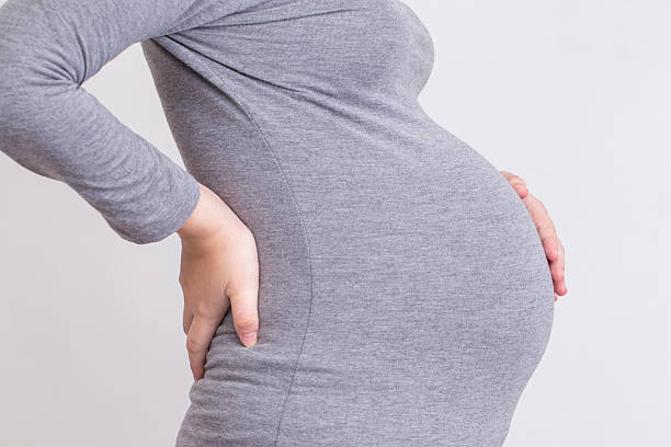 妊娠中の女性は、腰痛と接触した胴体 - human pregnancy backache massaging back ストックフォトと画像