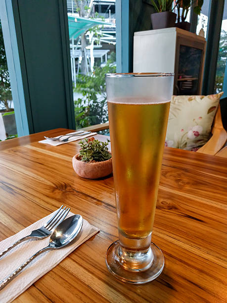 Glass of beer on wooden table in restaurant