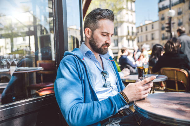 istock young man sitting in sidewalk cafe, Paris 539841308