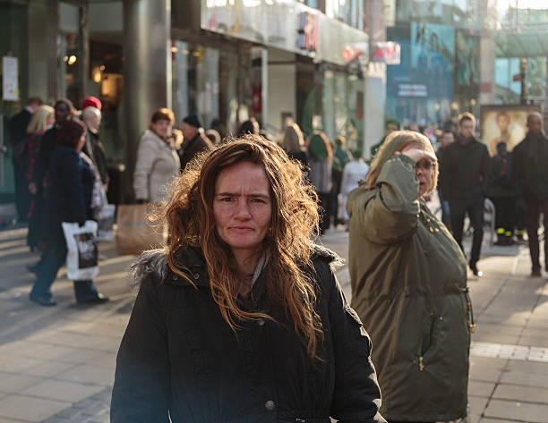 Homeless woman on city highstreet stock photo