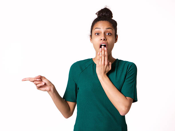 istock Young woman with shocked expression pointing at copy space 539842938