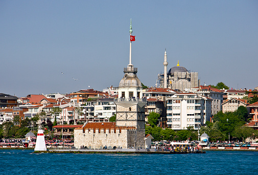 Istanbul, Turkey - May 8, 2016: Small boat view with Maiden's Tower in Istanbul, It's one of the symbols of Turkey and there is a part of the Bosphorus at the background with people. Some of people visits the restaurant in tower.