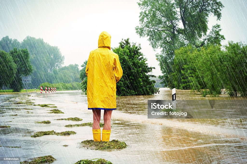Flooded street Woman standing in a flooded street Flood Stock Photo