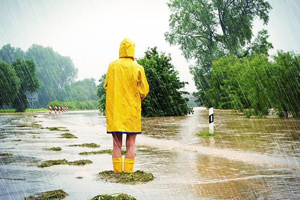 Flooded street Woman standing in a flooded street raincoat photos stock pictures, royalty-free photos & images