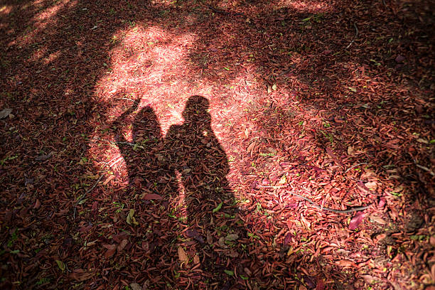 man and girl shadow on a red dry leave