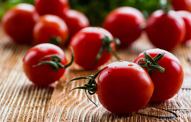 istock Small cherry tomatoes on wooden background, selective focus 539847958
