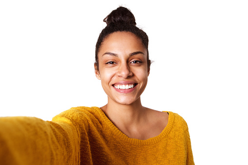 Close up portrait of cheerful young african woman taking selfie on white background