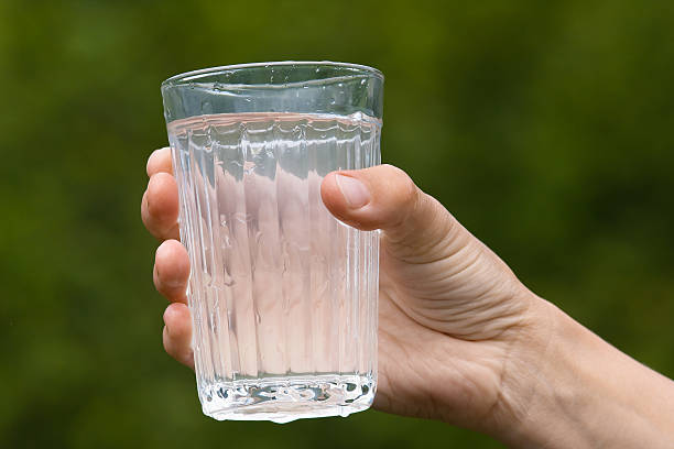 istock hand holding glass with water 539849896